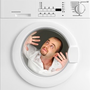 Man appearing to be trapped inside a clothes dryer, emphasizing dryer safety and maintenance concerns.