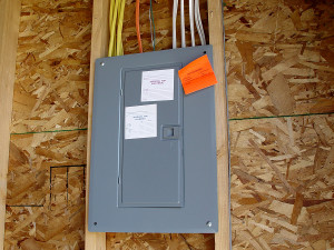 Electrical panel installation with labeled circuits and inspection notices, showcasing proper wiring and adherence to upgrade guidelines.