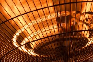Close-up of an electric heater with glowing heating elements, illustrating the interior components relevant to electric heat installation and maintenance.