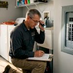 Electrician inspecting home electrical panel
